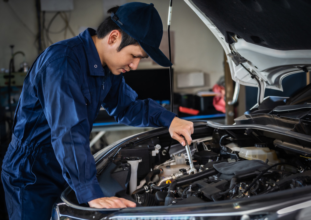 A Singapore car workshop specialist is servicing a hybrid car's engine.